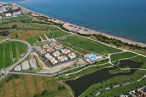 An aerial view of a coastal resort with a marina, swimming pool, and landscaped areas. - Villaggio Laguna Blu (Caorle)