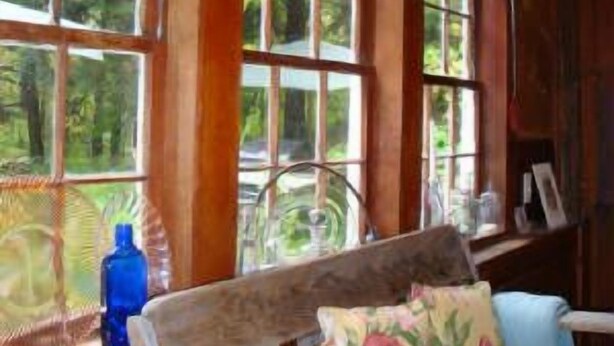 A room with large windows, wooden beams, and a bed with floral pillows. - Chestnut Lodge (Lee)