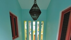 En trappe med gelænder i gult, der fører op til en platform med en hængende lampe.