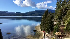 A view of a lake with a dock, a gazebo, and a forested area. - The Tuwanek Hotel and Spa (Sechelt)