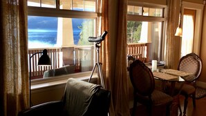 A room with a view of the ocean, a dining table, chairs, and a lamp. - The Tuwanek Hotel and Spa (Sechelt)