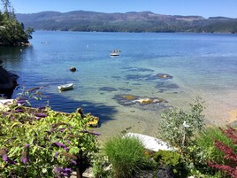 Un lago tranquilo con agua cristalina, barcos y vegetación circundante.