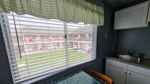 A kitchen with a window, a table, and a cabinet. - Flagship Motor Court (Hampton)