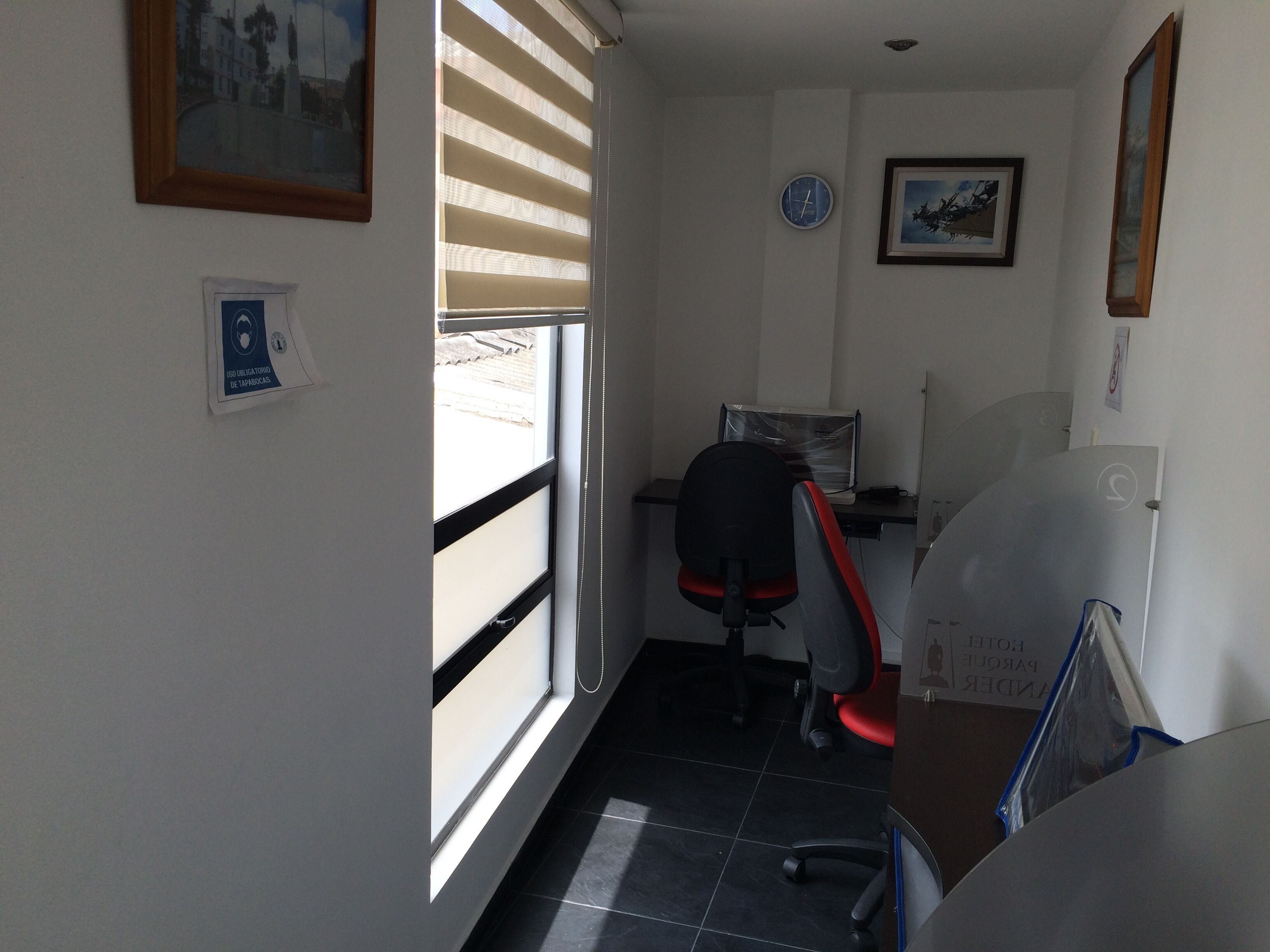 A small office with a desk, chair, and a window with blinds.