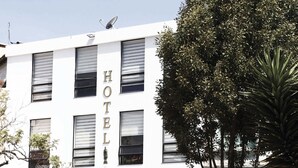 A white building with the sign "HOTEL PARQUE SANTANDER" and multiple windows.