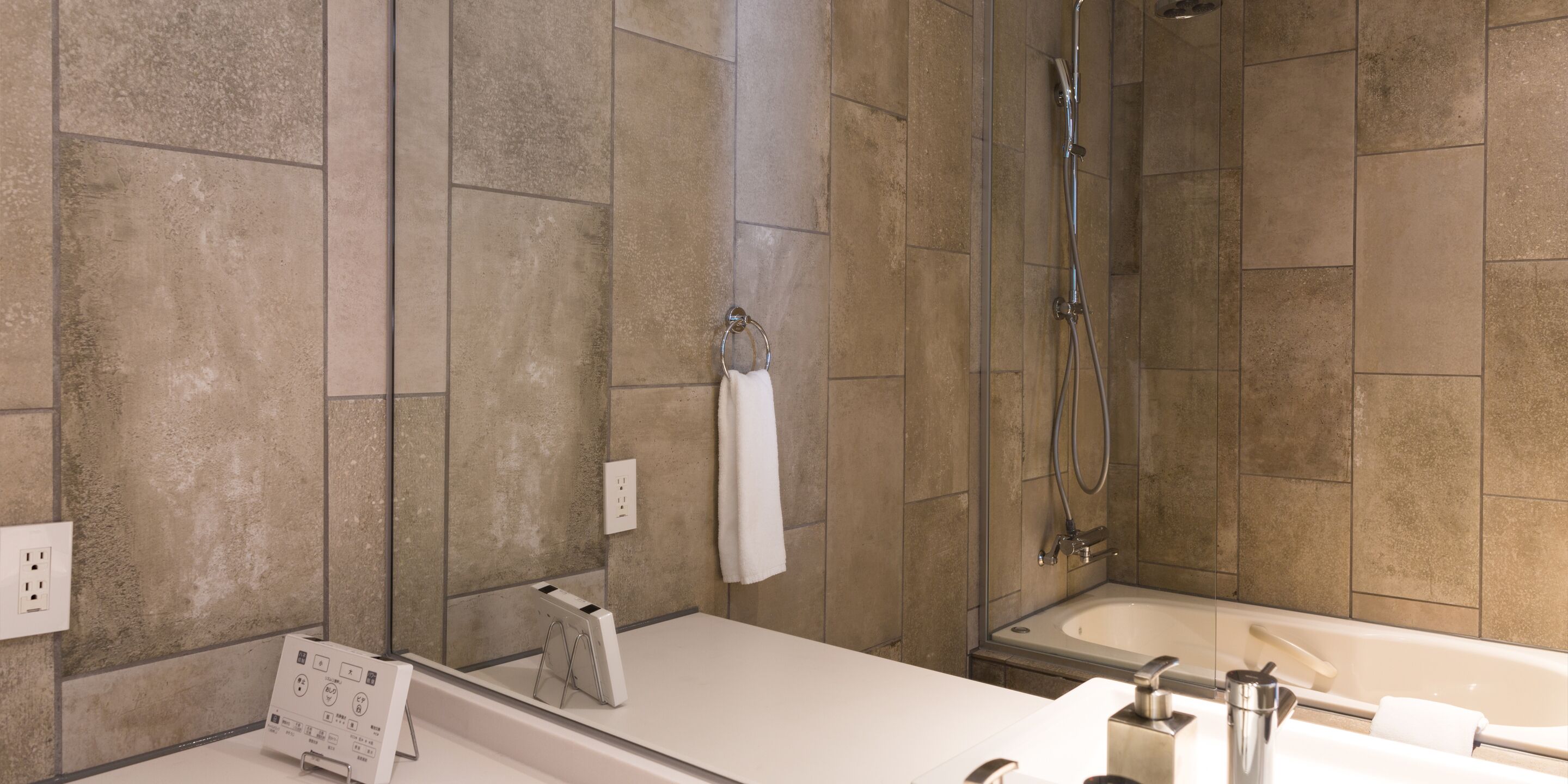A modern bathroom with a bathtub, shower, and a vanity with a mirror.