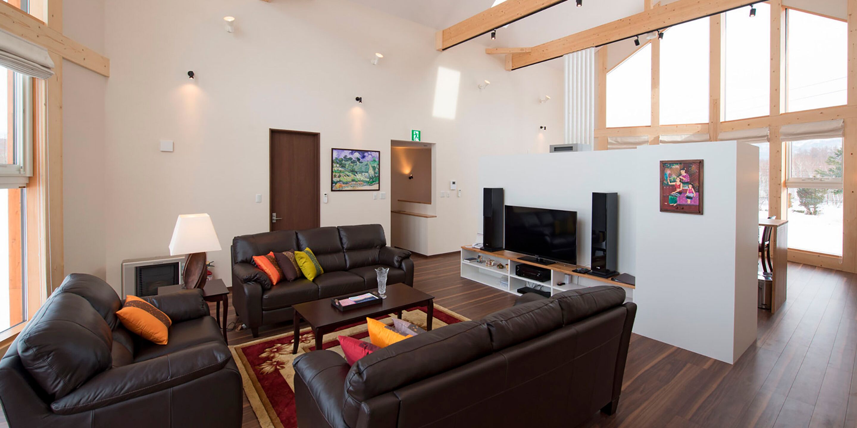 Uma sala de estar moderna com sofás de couro, uma TV de tela plana e obras de arte nas paredes.