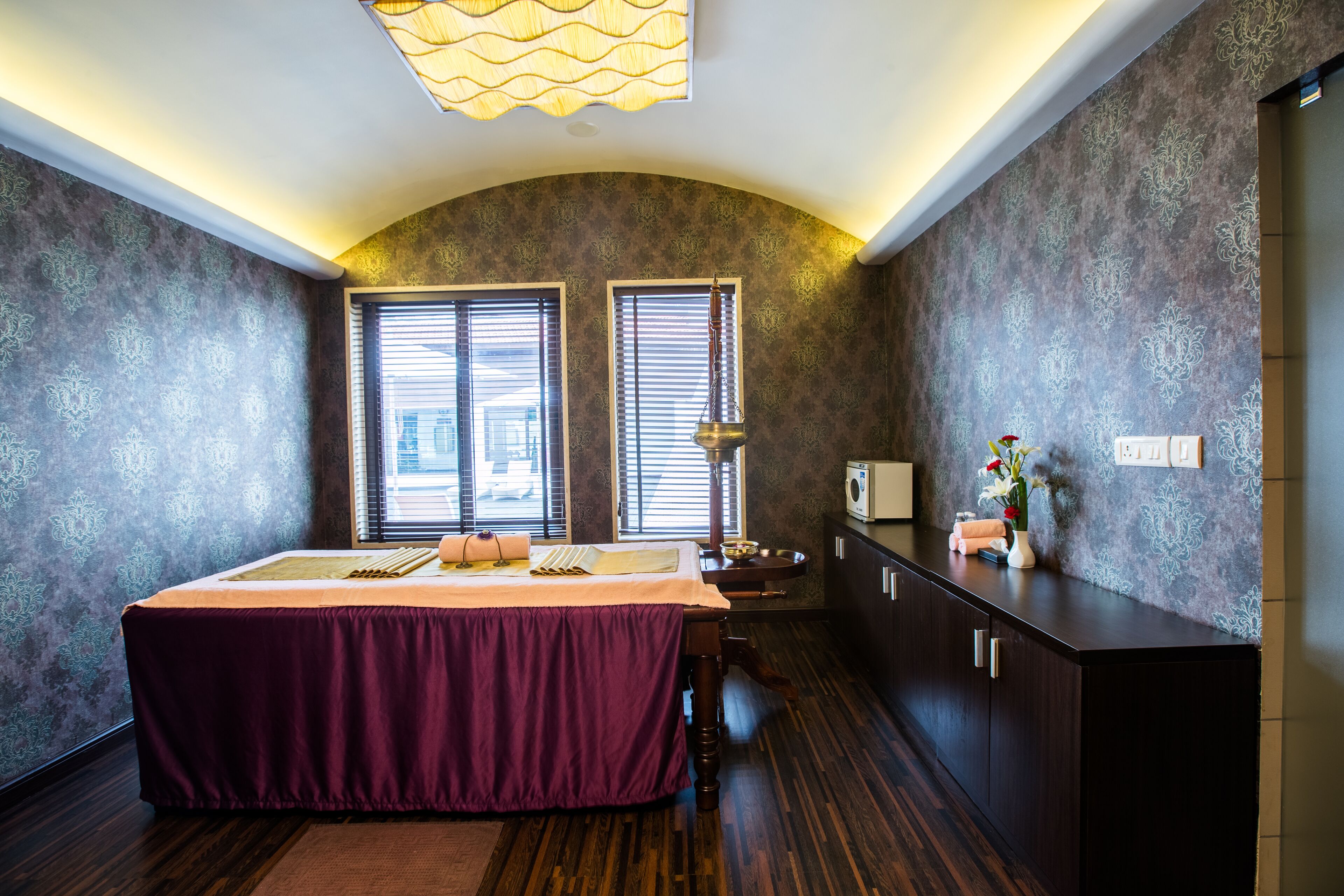 A bedroom with a bed, a desk, and a vanity.