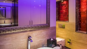 Un bagno moderno con un lavandino bianco, uno specchio grande e una parete decorata di rosso.