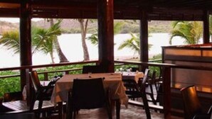 Un restaurante con terraza al aire libre con vista a la playa.