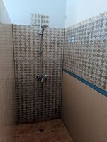 Zona de ducha con azulejos estampados y una banda azul decorativa.