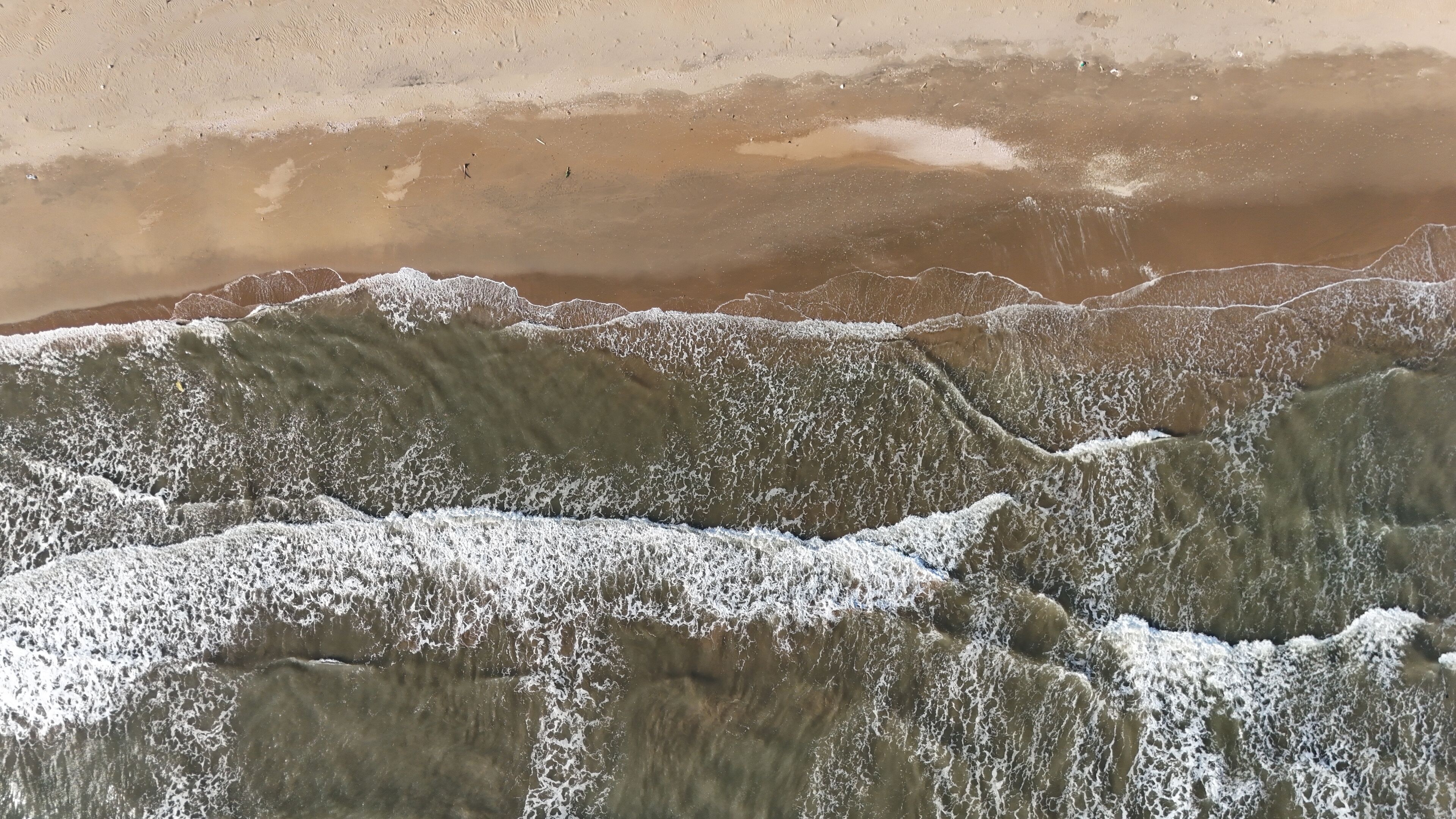 A beach with waves crashing onto the shore.