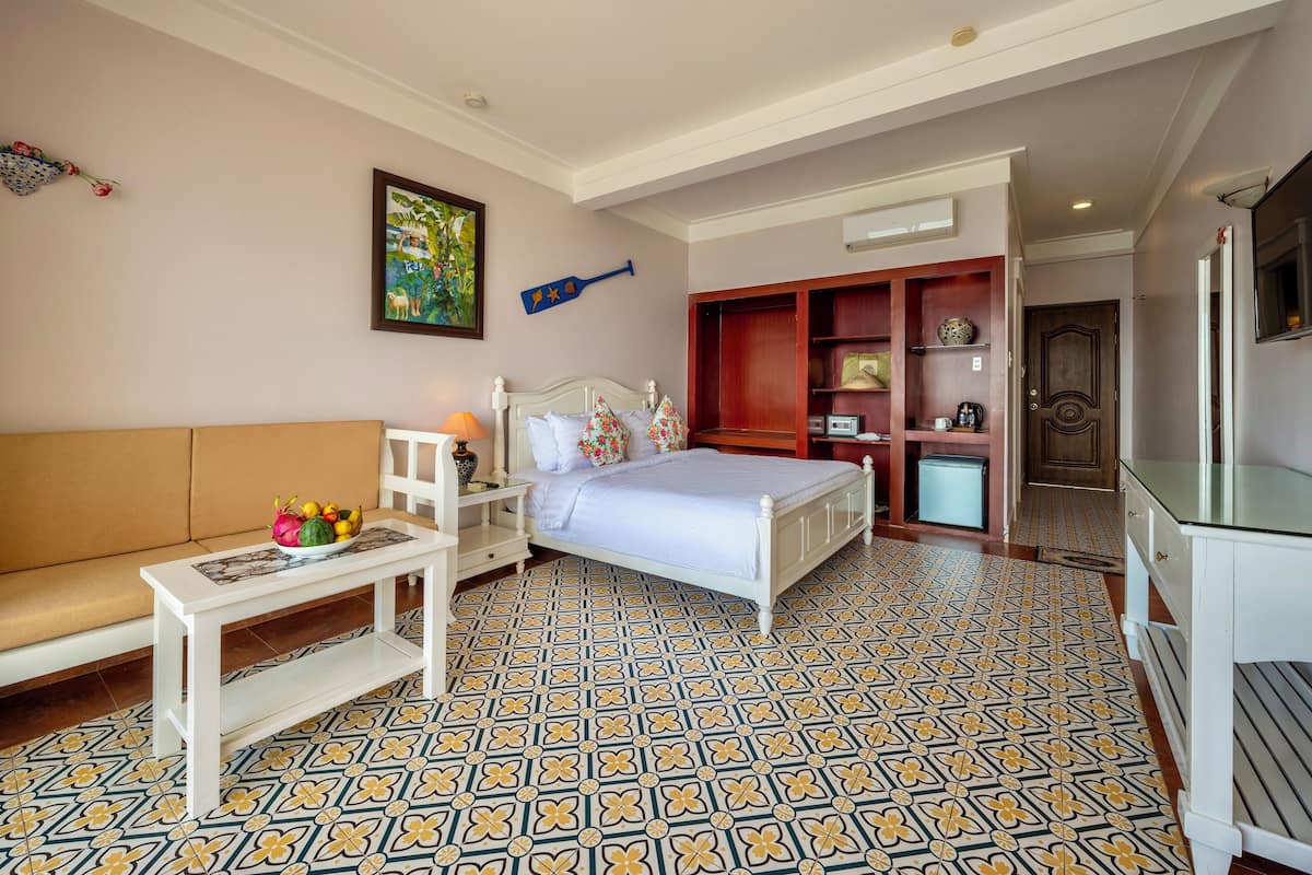 Een hotelkamer met een bed, een bank, een klein tafeltje en een televisie.