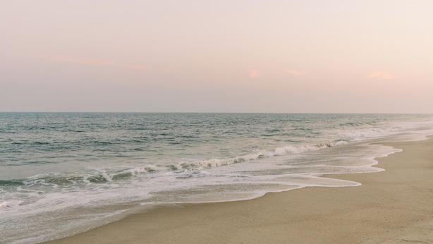 A beach with waves gently lapping onto the shore.