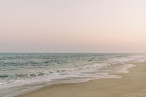 Una playa cerca, arena blanca, sillas reclinables de playa, sombrillas