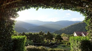 A view through a natural archway with a house visible in the foreground and mountains in the background. - Cilan Resort (Datong)