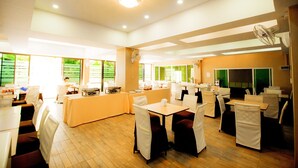 A spacious dining area with multiple tables and chairs, a central buffet table, and large windows providing natural light. - The Rama Residence Chiang Rai (Chiang Rai)