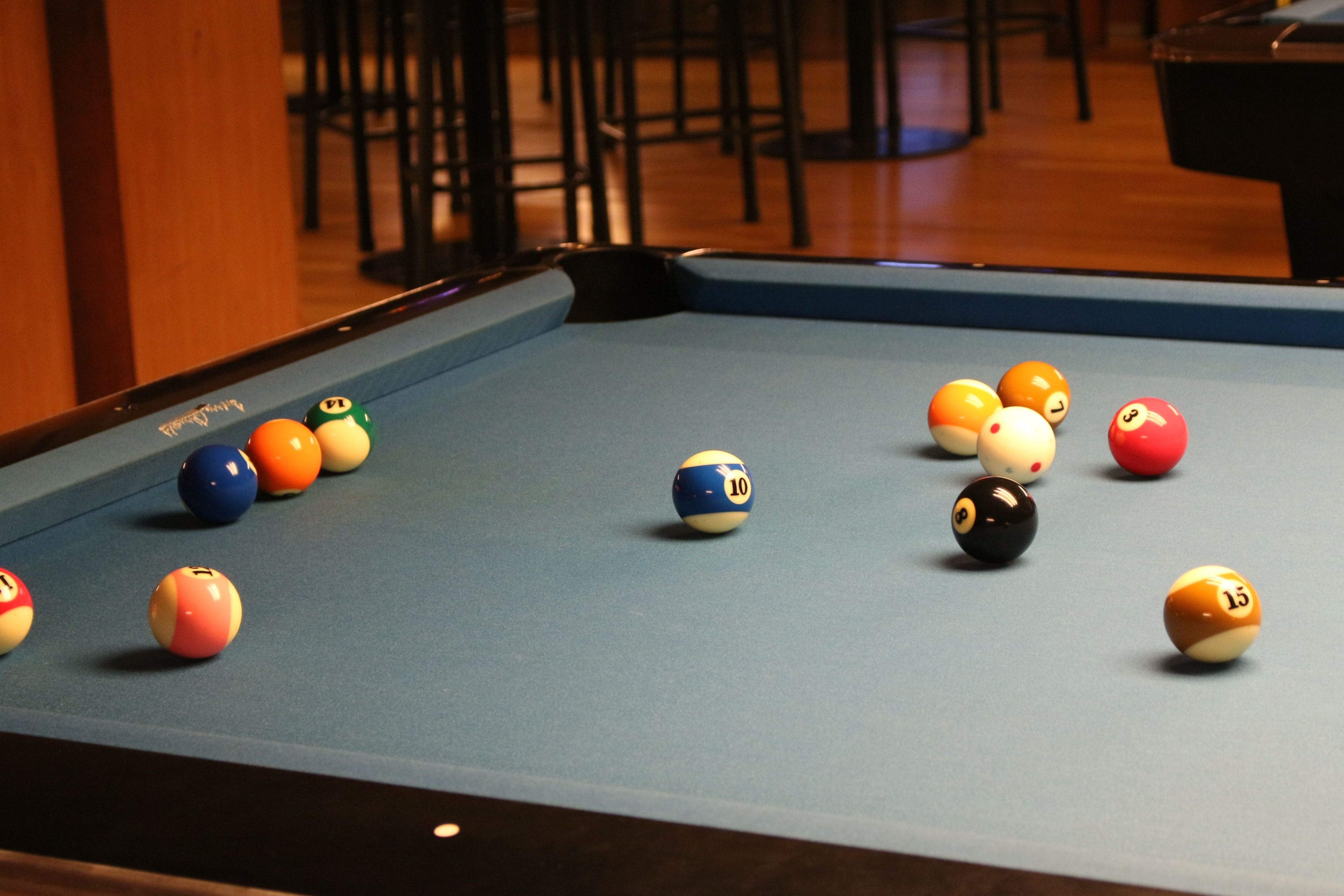 Een pooltafel met genummerde ballen in verschillende kleuren.