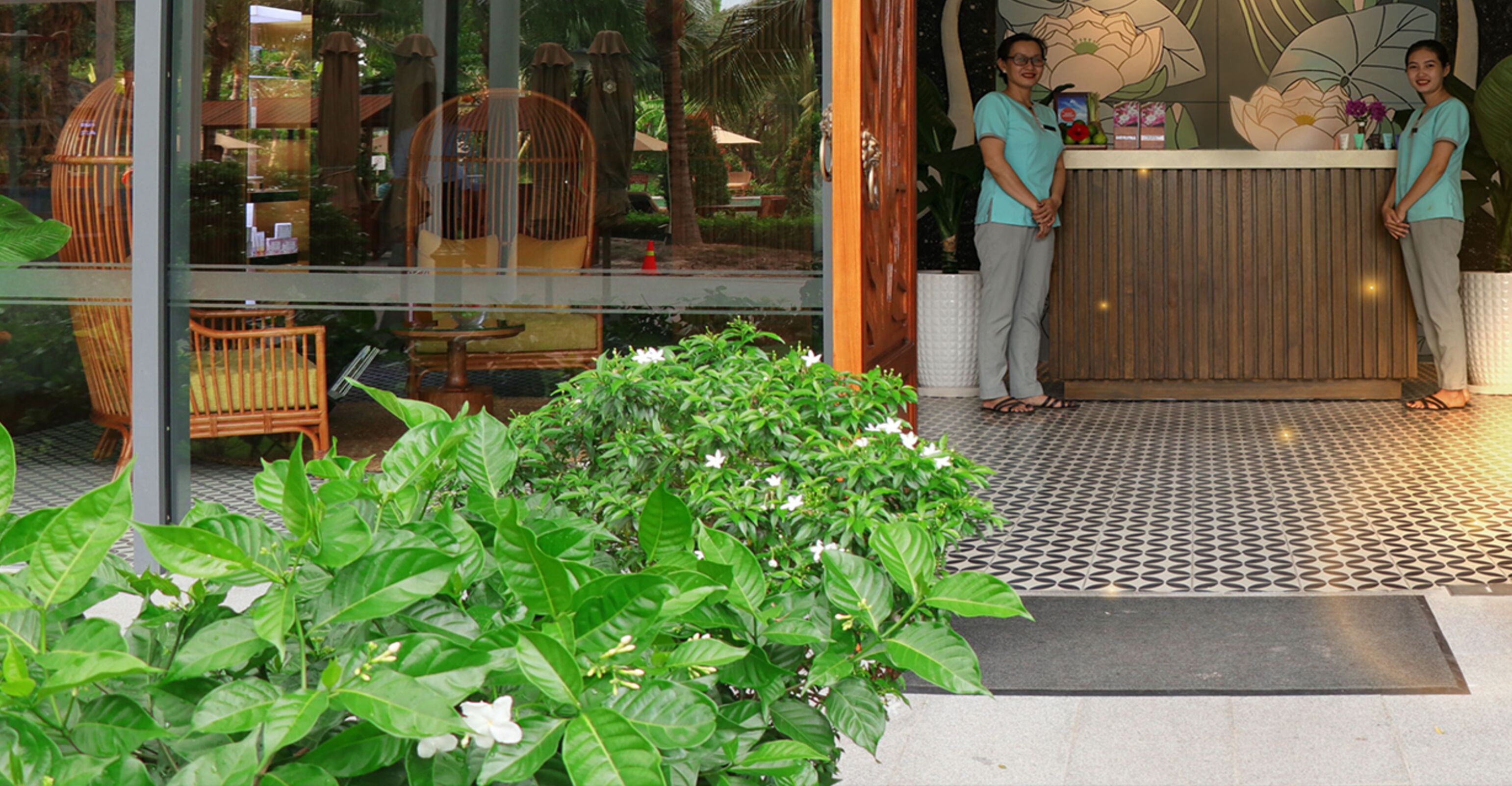 A reception area with a wooden counter, a glass door, and a tiled floor.