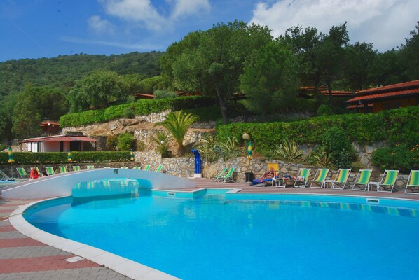 Alberca al aire libre, sombrillas en la alberca y camastros