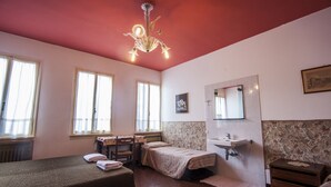 Un dormitorio con una cama, un escritorio, una silla, un aparador, un espejo y una ventana.