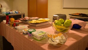 A buffet table with various food items and condiments.
