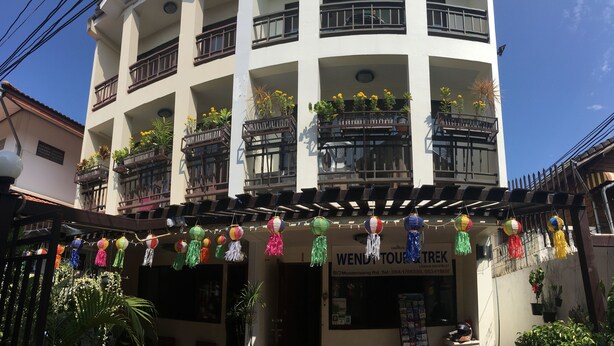 Un immeuble à plusieurs étages dont les balcons sont ornés de plantes et de fleurs.