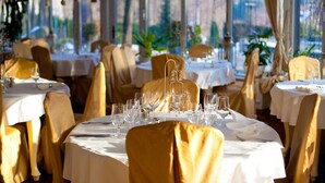A restaurant with round tables, gold chairs, and white tablecloths. - Hotel Szrenicowy Dwór (Szklarska Poreba)