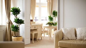 A cozy living room with a beige sofa, a small table with a plant, and a chair. - Hotel Szrenicowy Dwór (Szklarska Poreba)