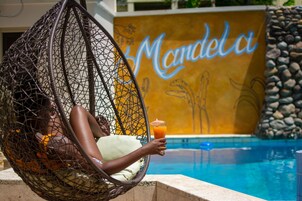 Una piscina al aire libre, sombrillas, sillones reclinables de piscina