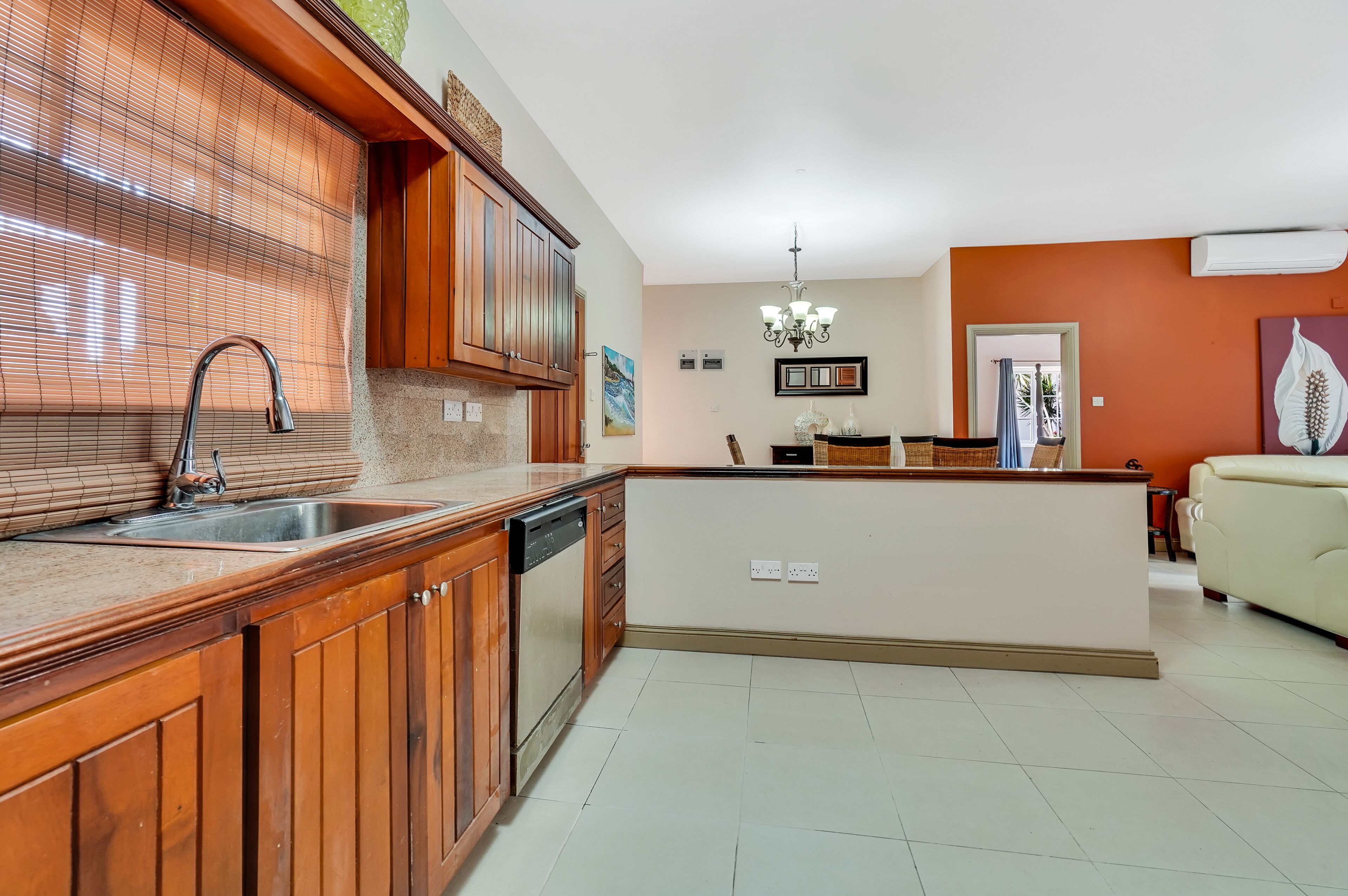 A modern kitchen with wooden cabinets, a built-in dishwasher, and a central island.