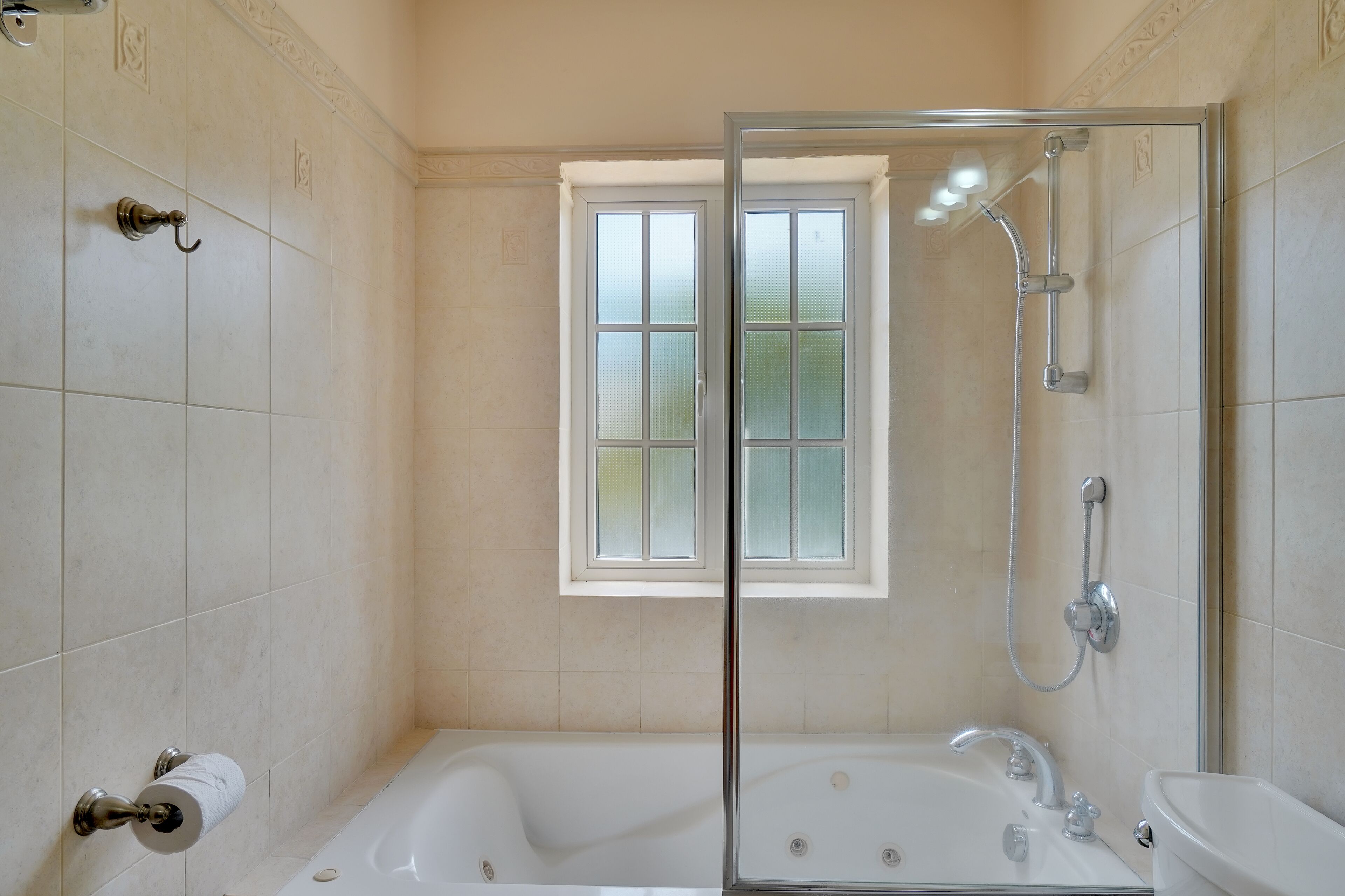 Un baño con ducha de vidrio, bañera, lavamanos e inodoro.