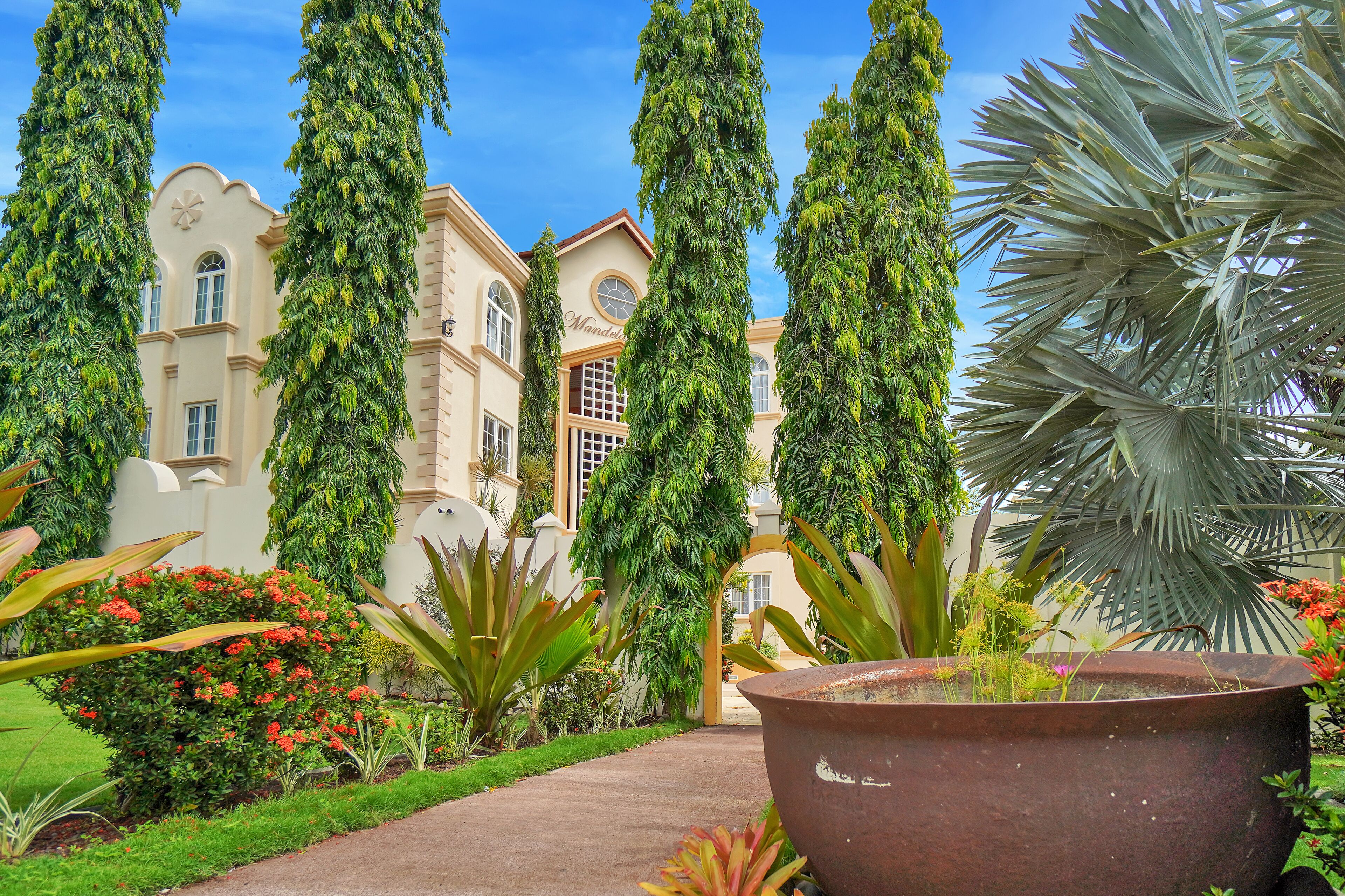 A building with a classic architectural style, surrounded by lush greenery and a well-maintained garden.