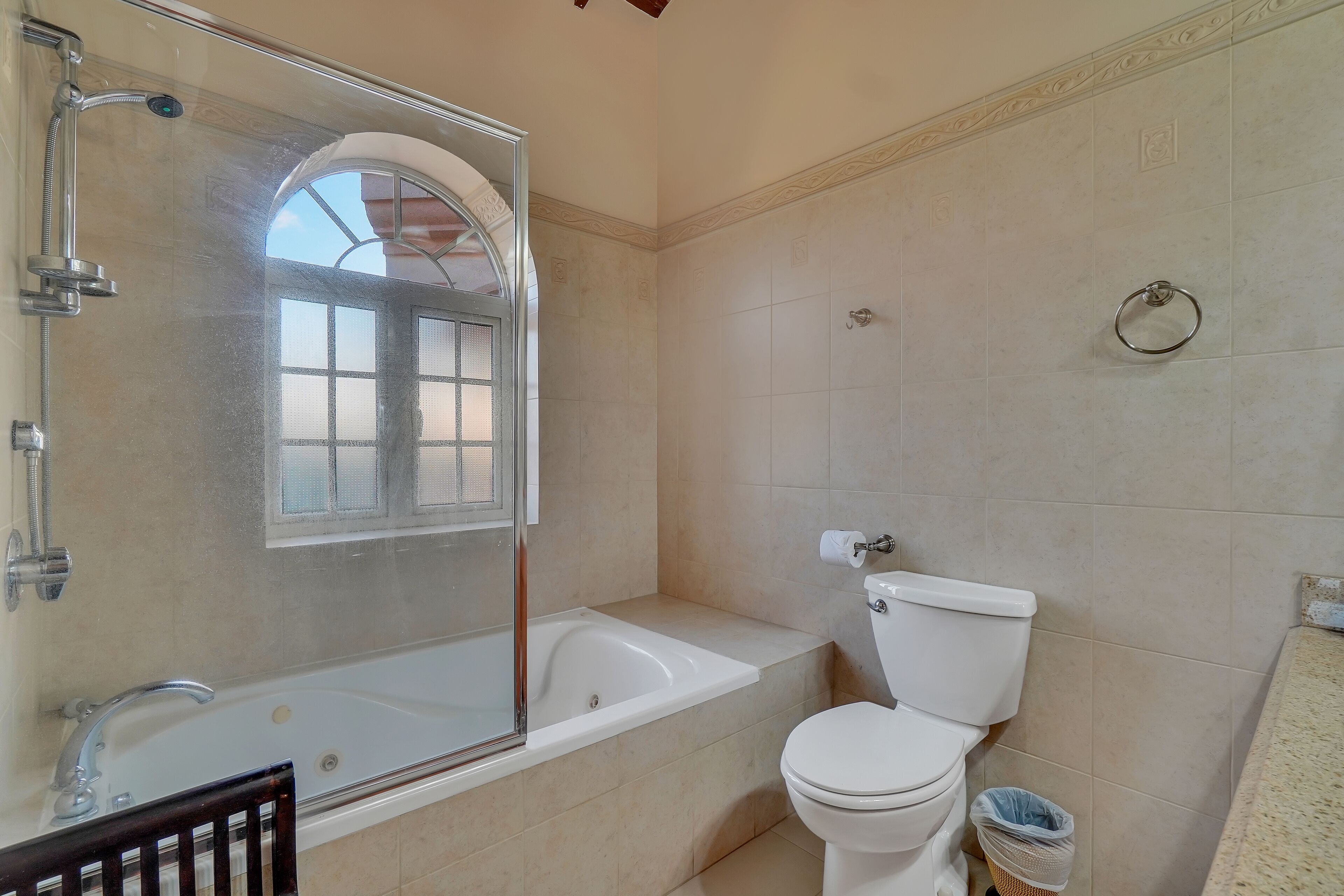 A bathroom with a bathtub, toilet, and a glass-enclosed shower area.