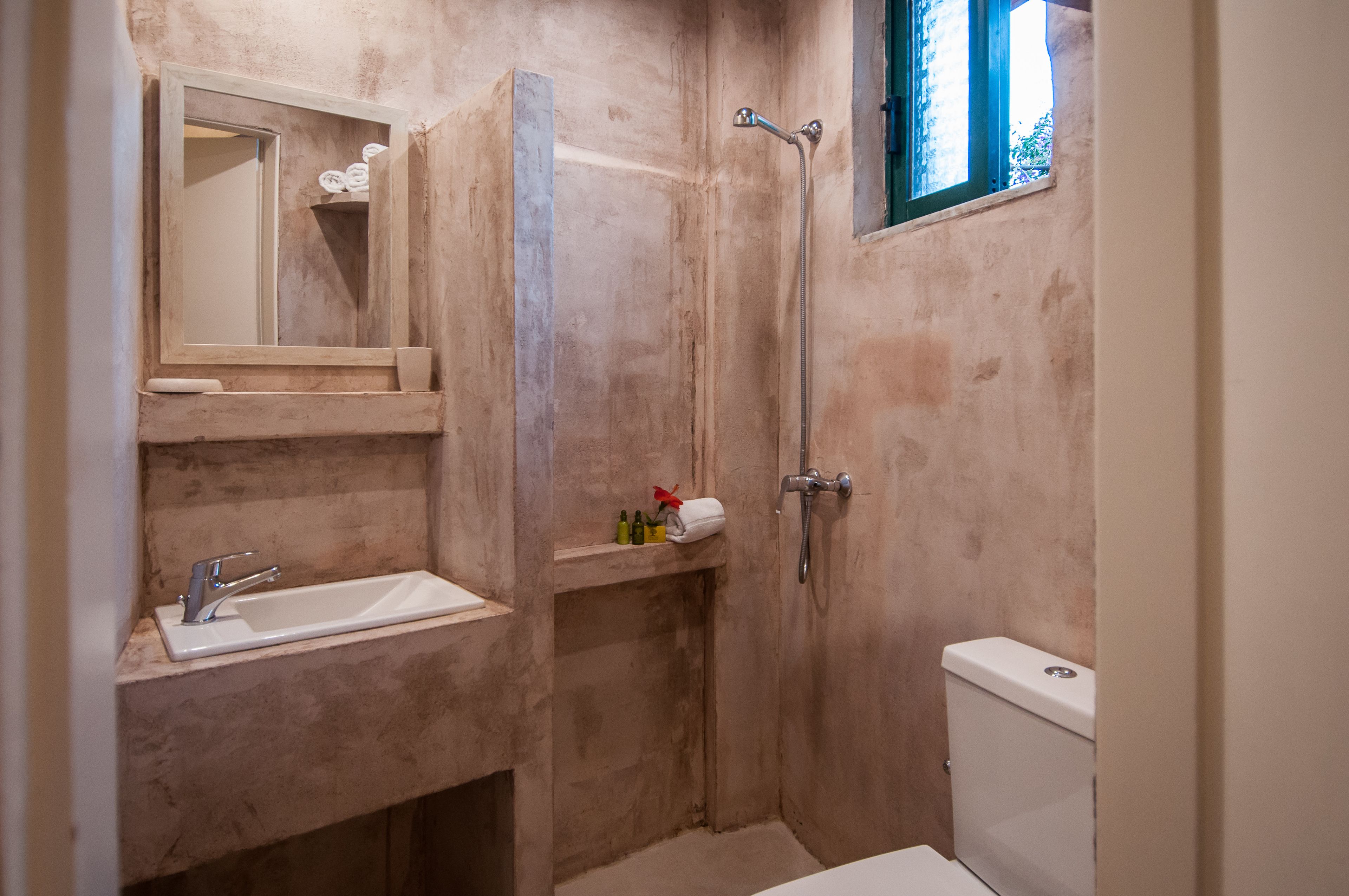 Un bagno con lavandino, specchio, doccia e WC.