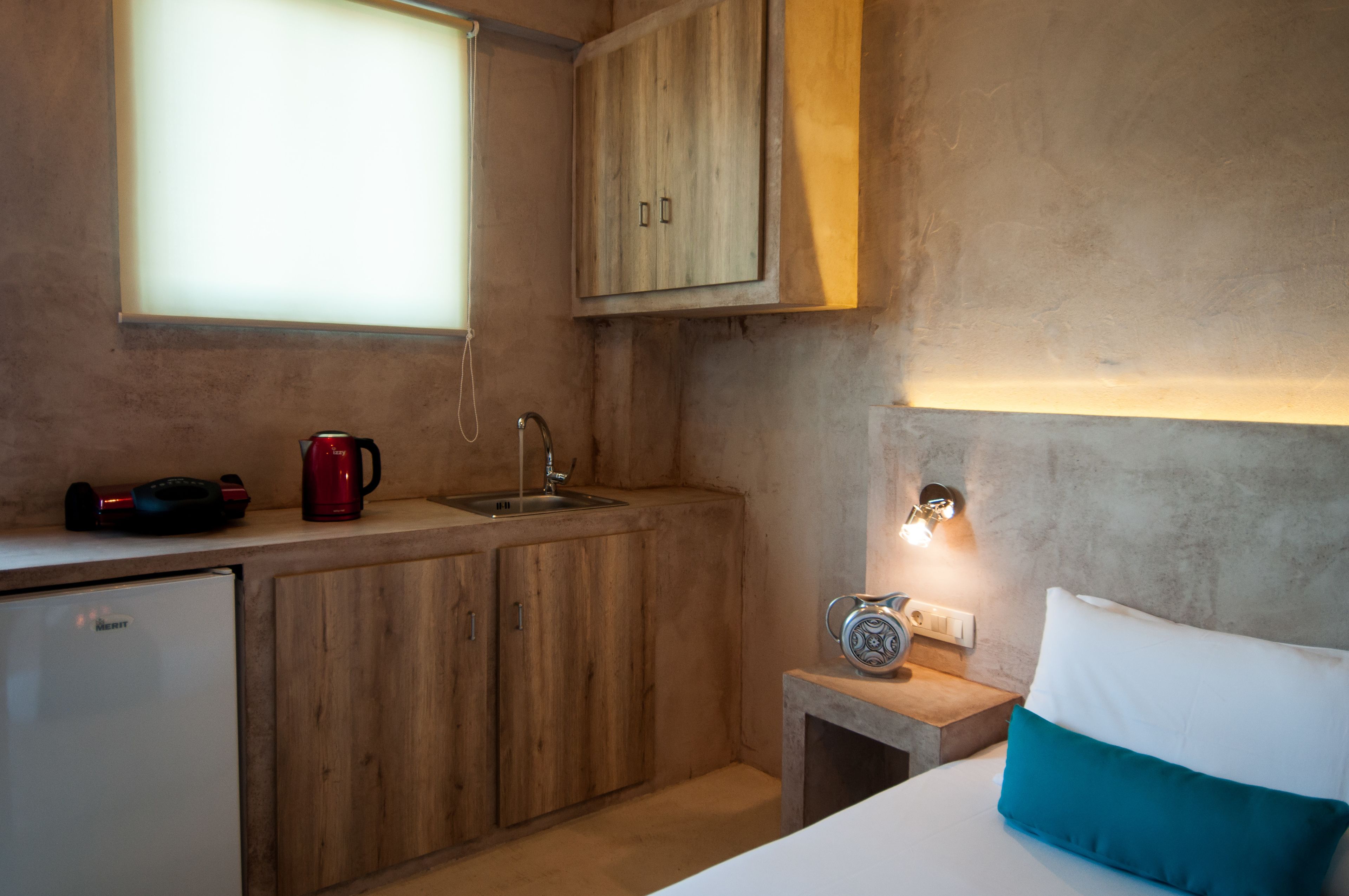 A compact kitchen with wooden cabinets, a sink, and a coffee maker.