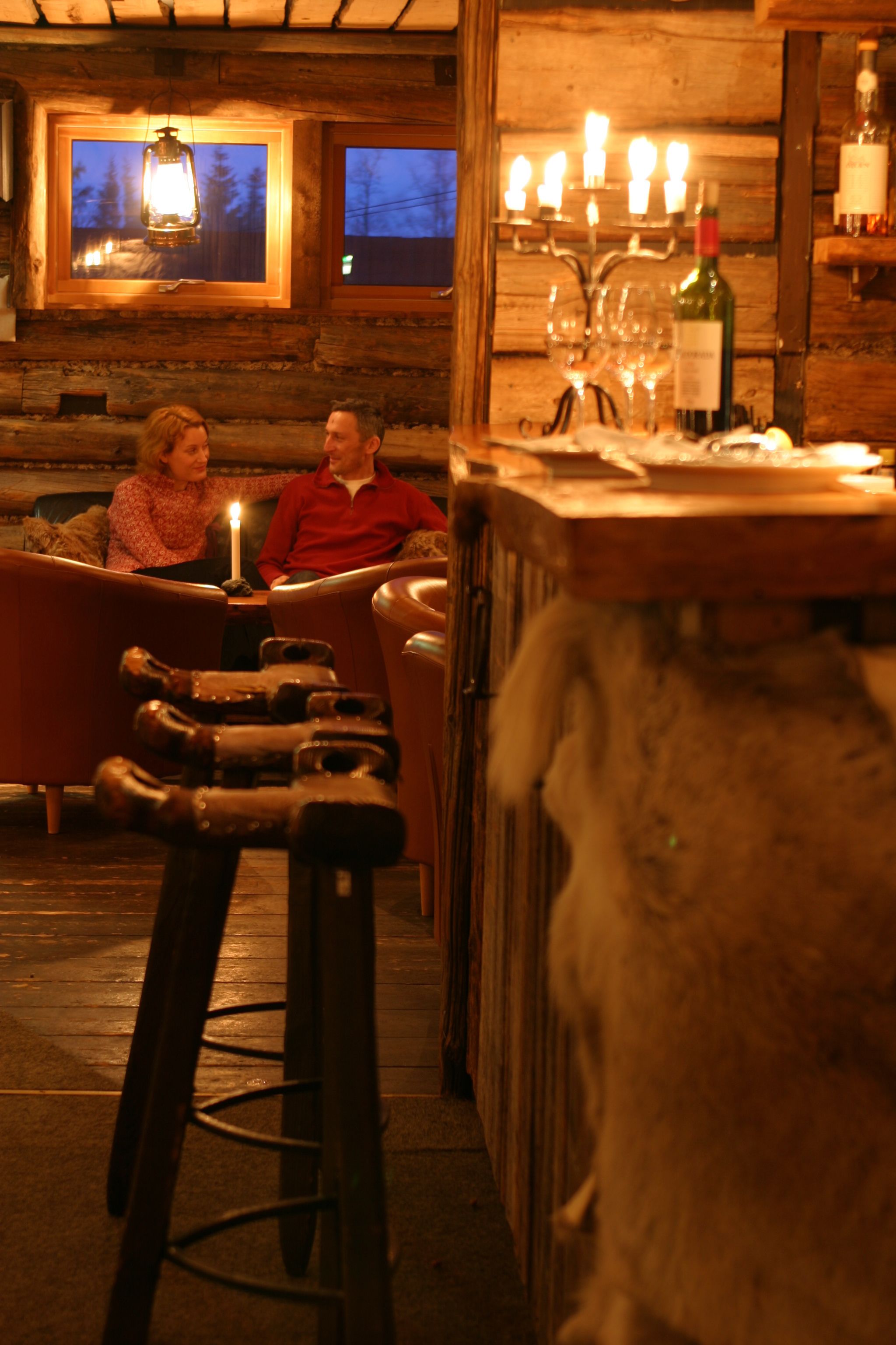 Un rincón de bar acogedor con muebles de madera, una barra y una botella de vino.