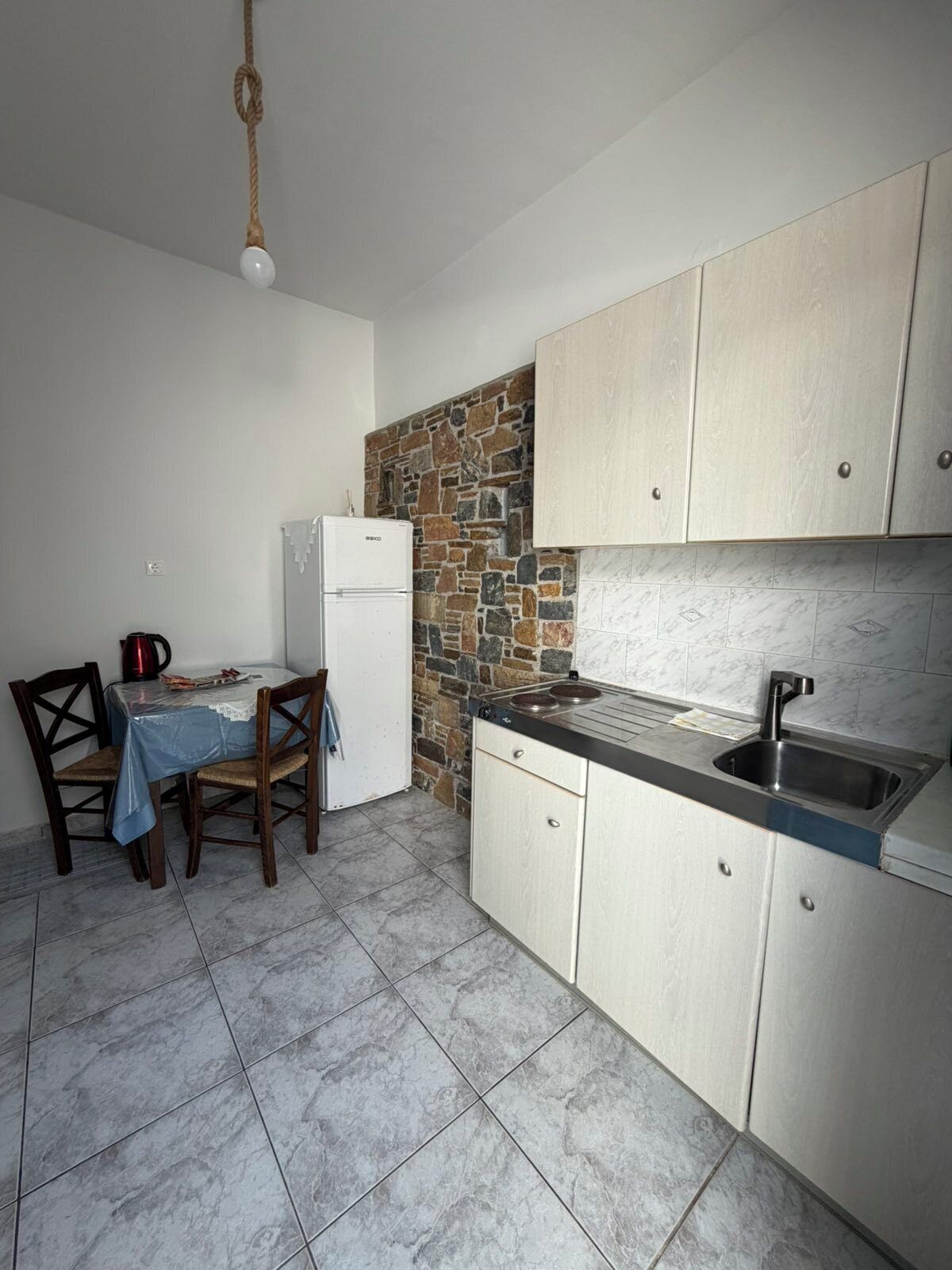 Frigorífico grande, placa de cocina y utensilios de cocina