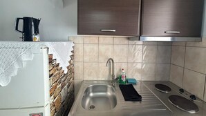 A kitchen with a stainless steel sink, a coffee maker, and a stove. - Foinikas Studios (Kithnos)