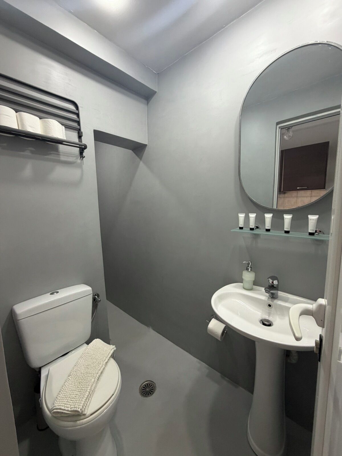 Een moderne badkamer met toilet, wastafel en spiegel.