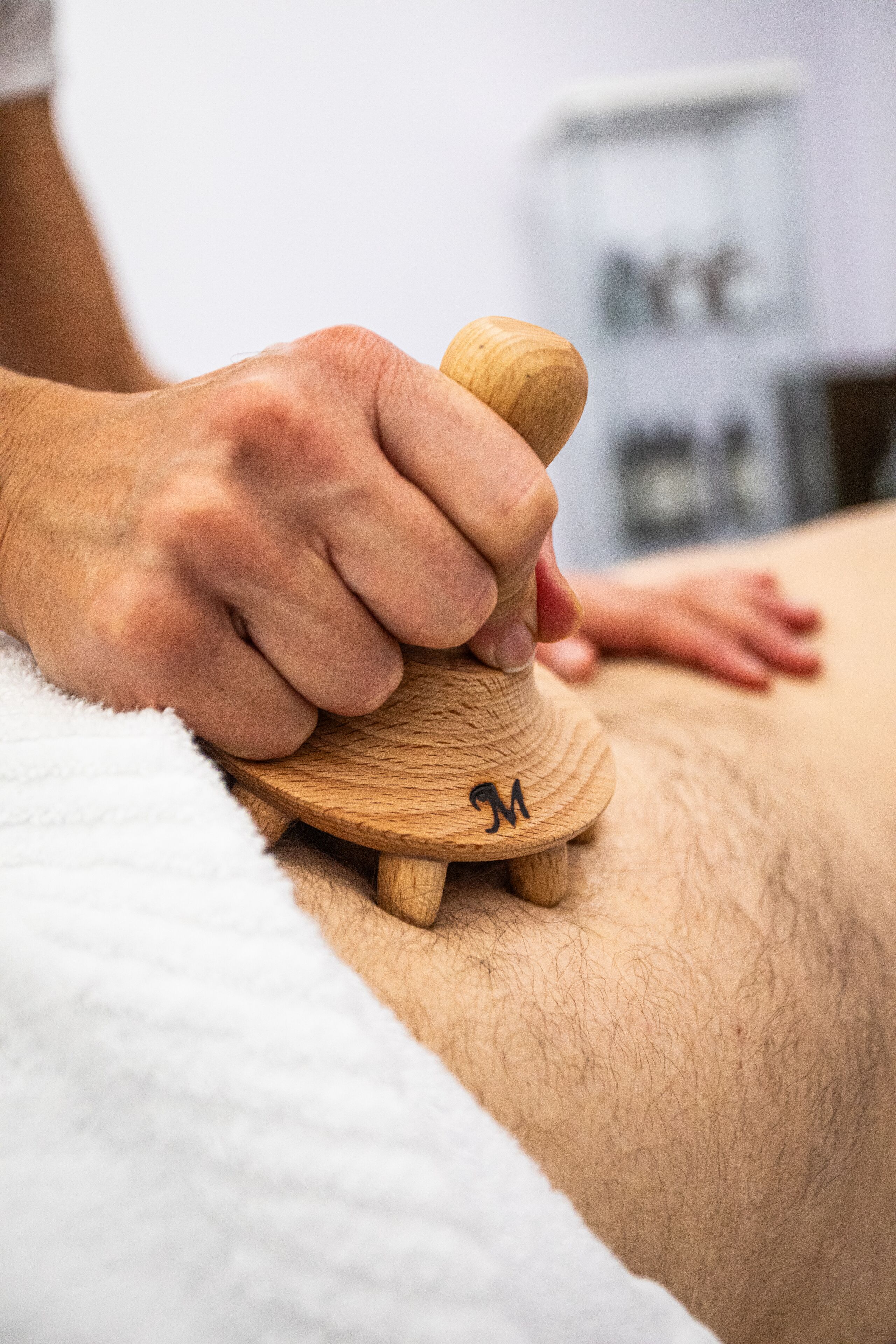 Gros plan d’un outil de massage en bois utilisé sur le dos d’une personne.