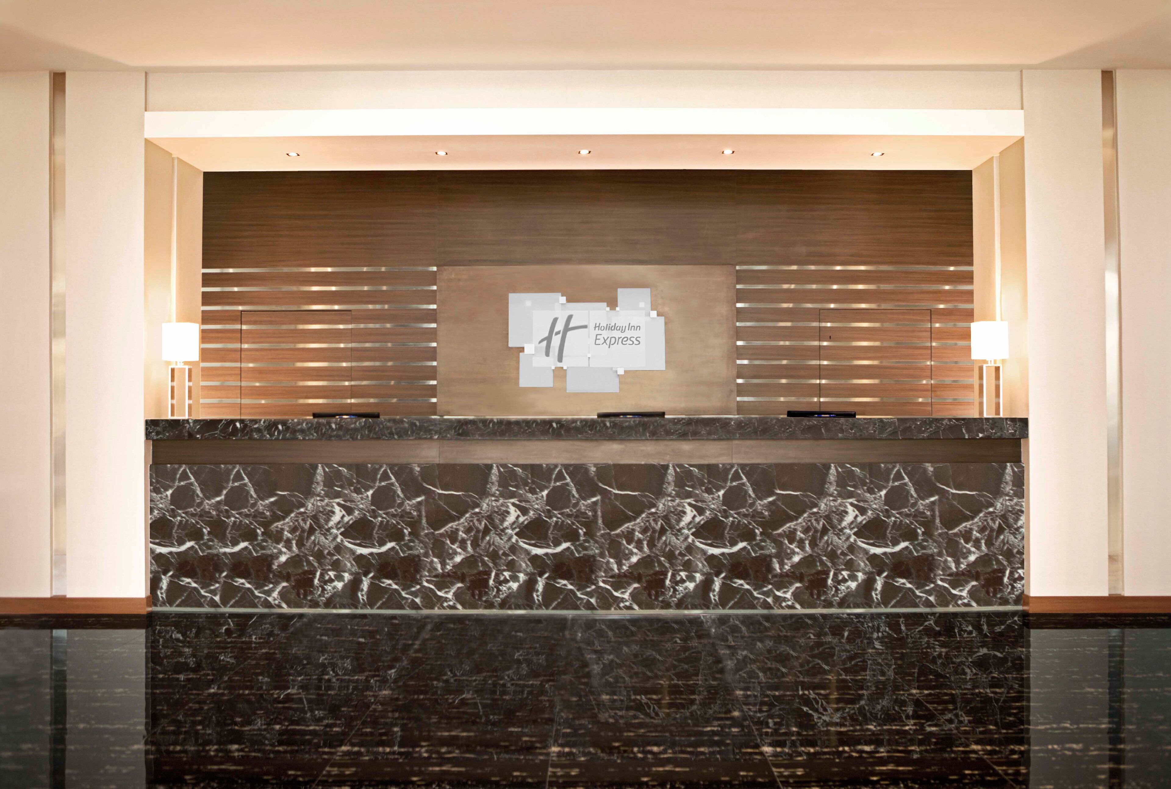 A reception desk with a marble front and a sign above it.