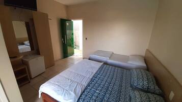 A bedroom with a bed, a desk, a chair, and a television.