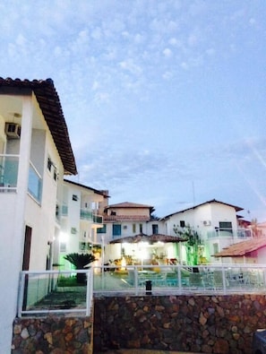 A residential area with multiple houses, a stone wall, and a swimming pool.