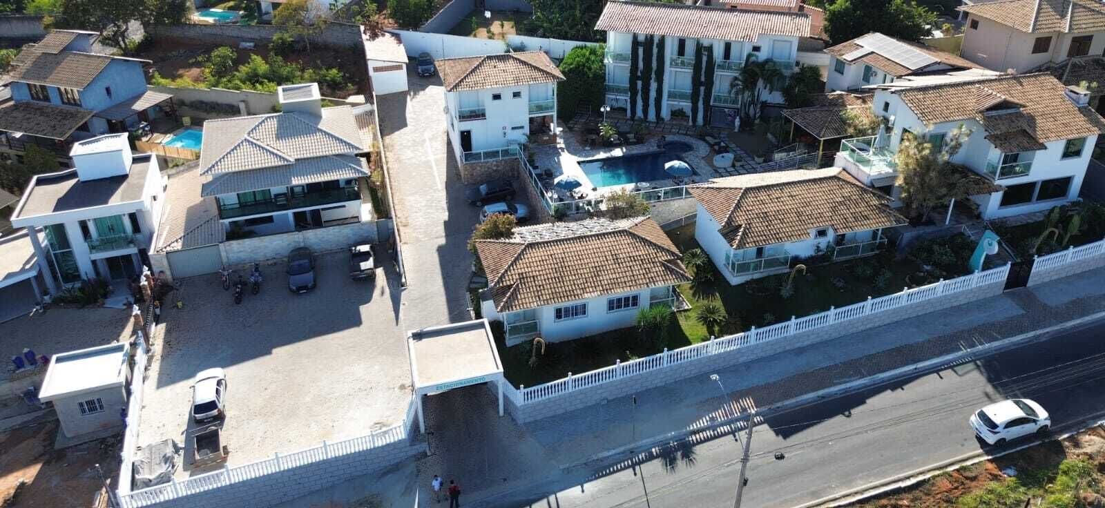A residential area with multiple houses, a swimming pool, and a road.