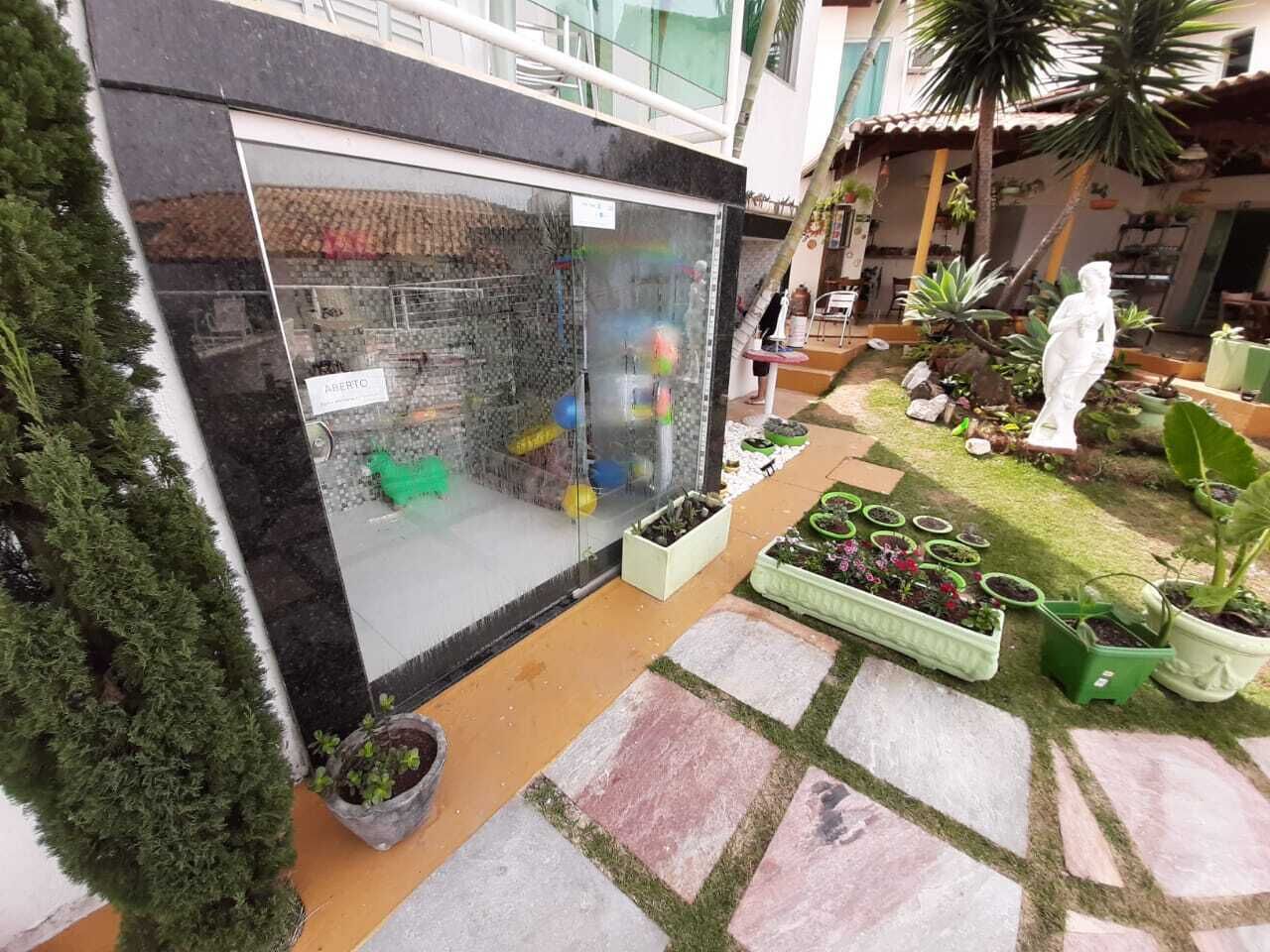 Une cour intérieure dotée d’une verrière, agrémentée de plantes en pot et ornée d’une statue.