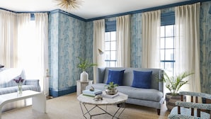 A living room with a sofa, coffee table, and patterned wallpaper. - The Christopher, The Edgartown Collection (Edgartown)