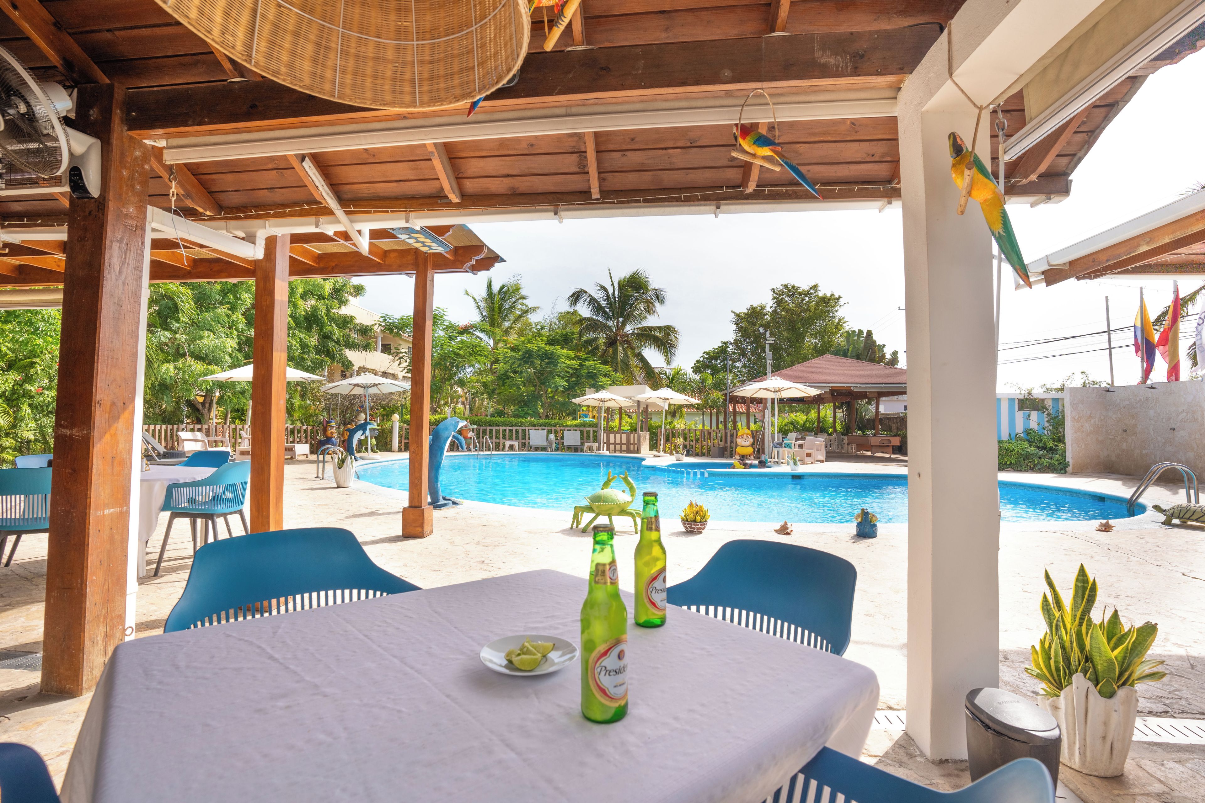 Ein Poolbereich mit Tisch, Stühlen und einer Bierflasche.
