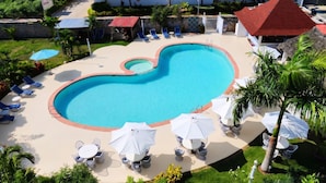 A swimming pool with lounge chairs and umbrellas, surrounded by greenery and a building labeled 'ESTRELLA DOMINICA'. - Casual Eden Bayahibe by Casual Hoteles (Dominicus)