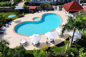 A swimming pool with lounge chairs and umbrellas, surrounded by greenery and a building labeled 'ESTRELLA DOMINICA'. - Casual Eden Bayahibe by Casual Hoteles (Dominicus)